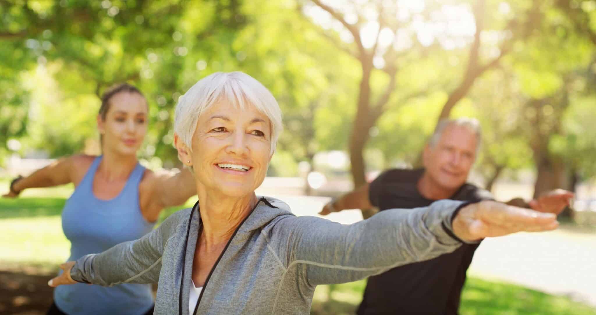 Older people doing yoga in a park